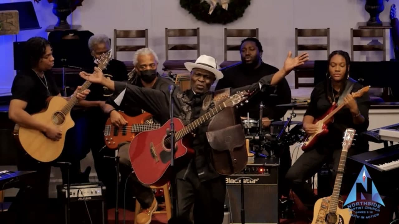 George Achini performing with his band at a church