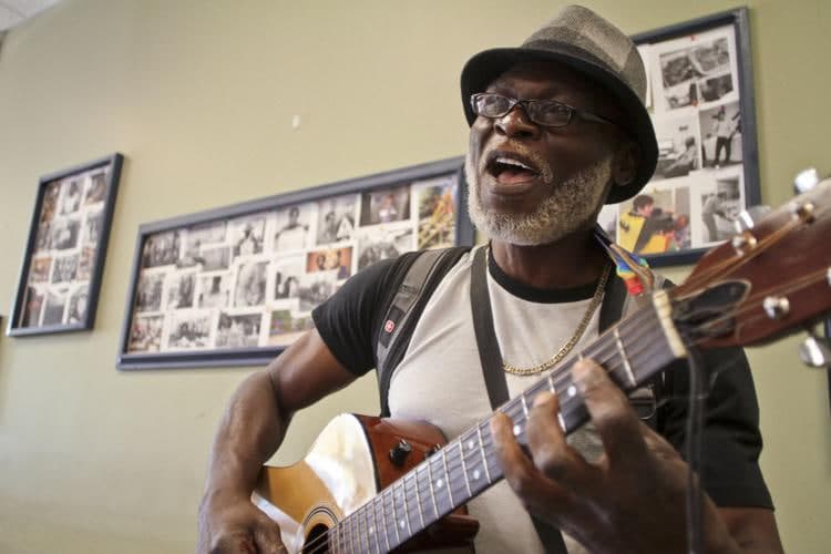 George Achini playing guitar at the Interactive Resource Center